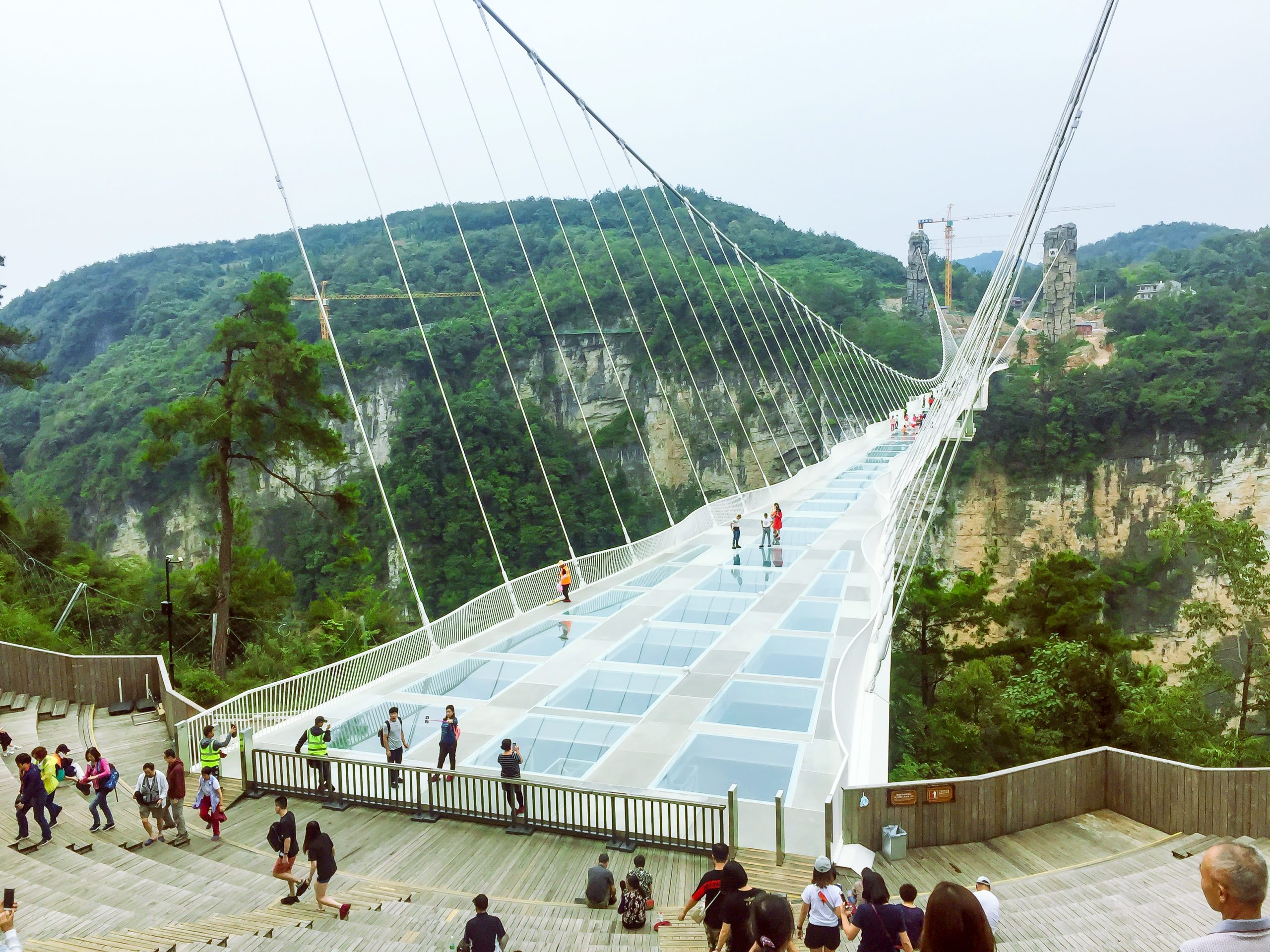 Tourists visit Zhangjiajie Glass Bridge crossing the grand canyon in Zhangjiajie National Forest Park 