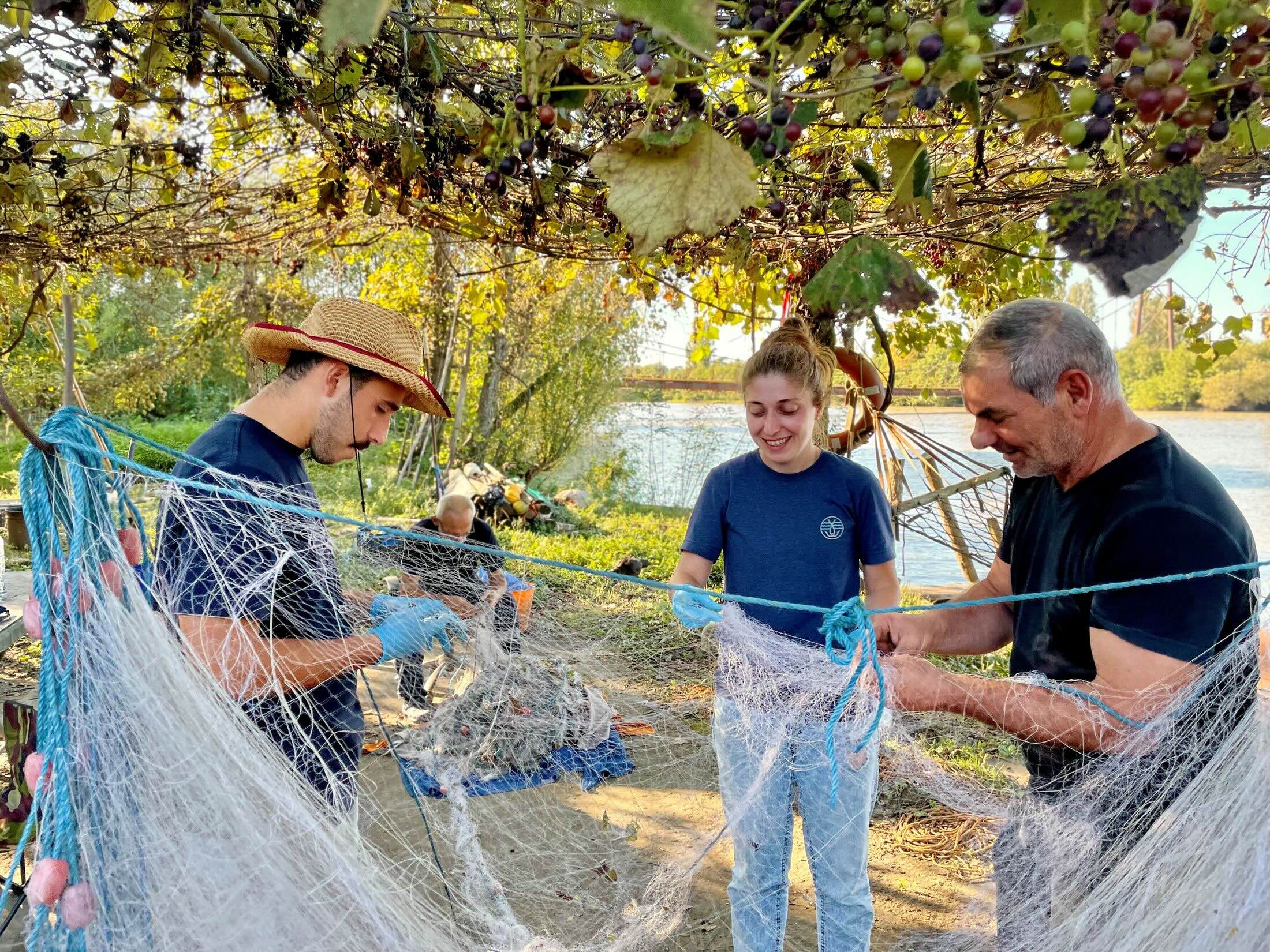 oane Bibileishvili, Tamar Edisherashvili and Dimitri Pipia cleaning a net beside the Rioni River